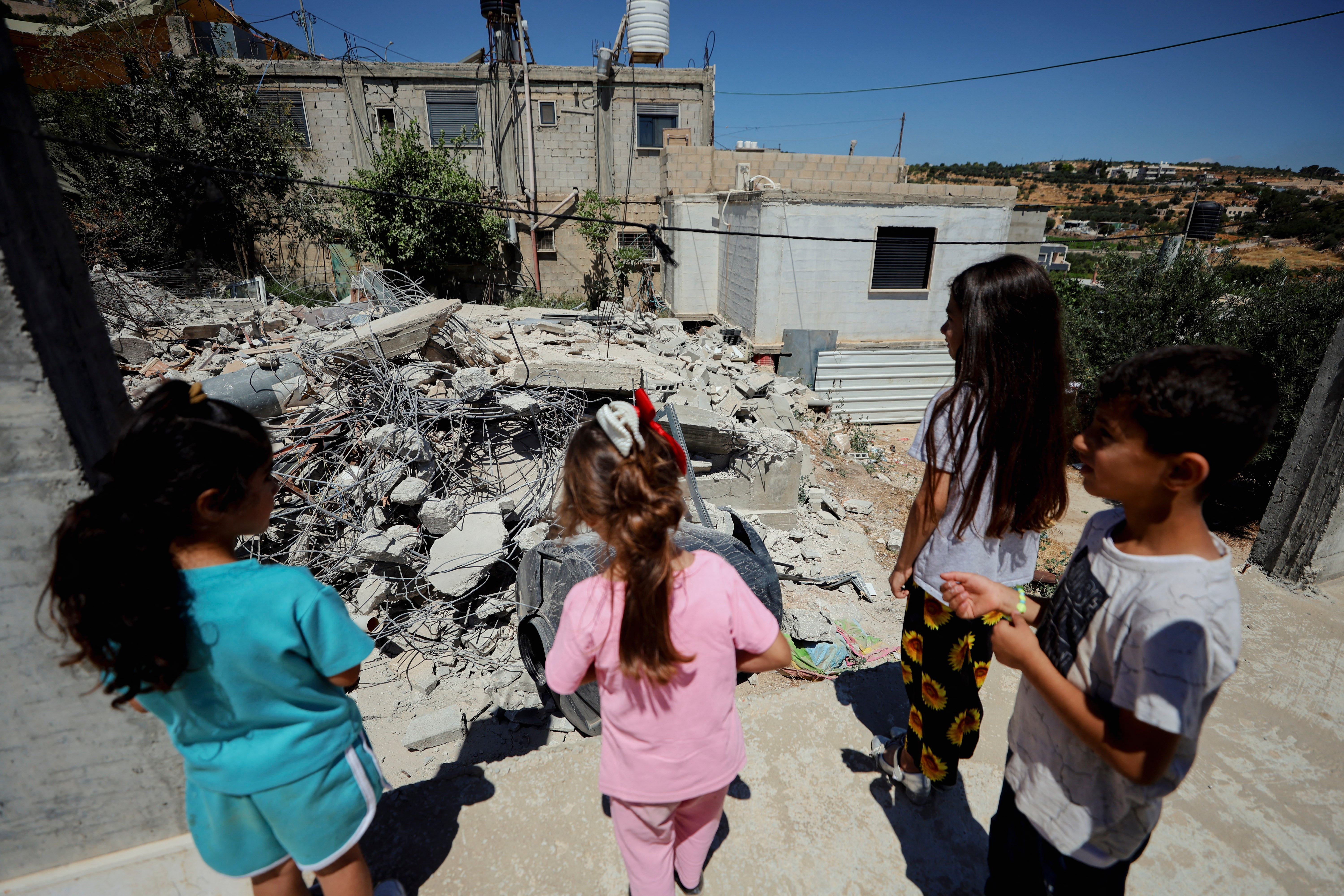 Palestinian children look at the rubble of demolished structures in Al Khadir, southwest of Bethlehem, in the occupied West Bank