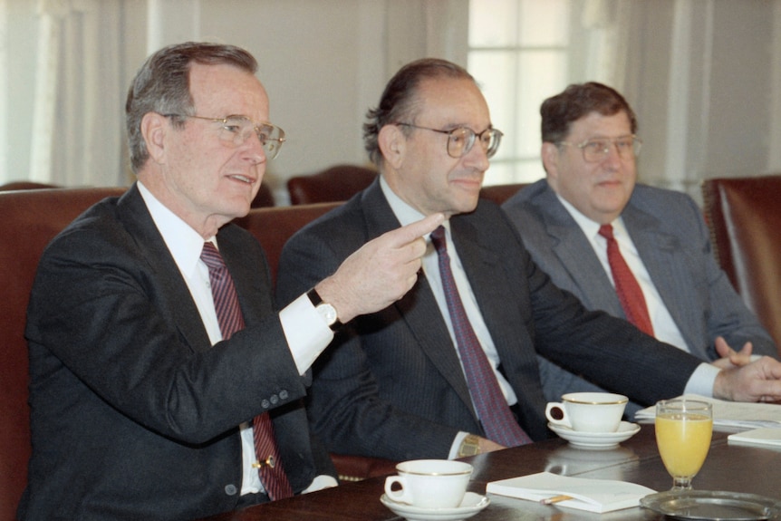 George Bush (left) sits beside Alan Greenspan (middle) with John Sununu beside him (right).
