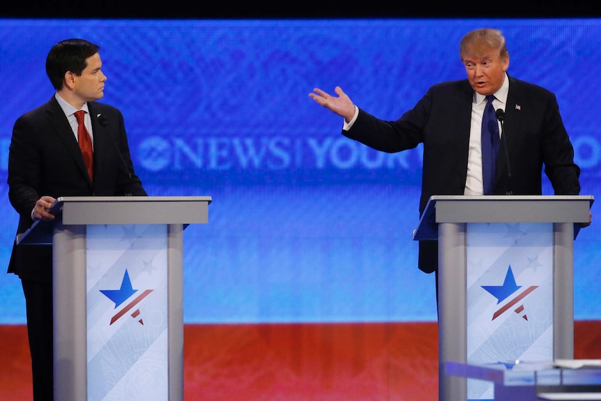 Marco Rubio listens to Donald Trump speak.