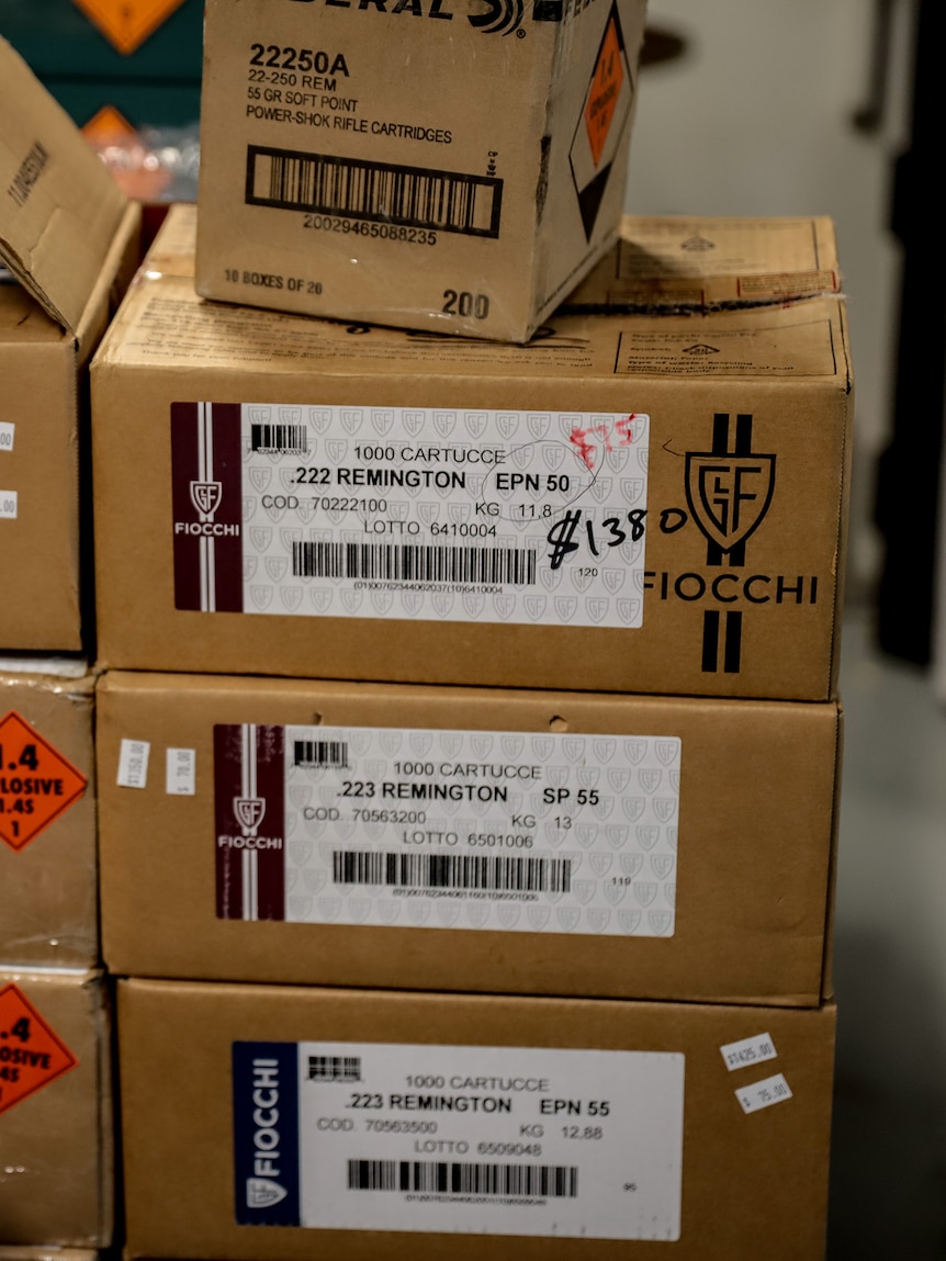 Brown cardboard boxes stacked on top of each other. They have a white label and an orange explosive label.