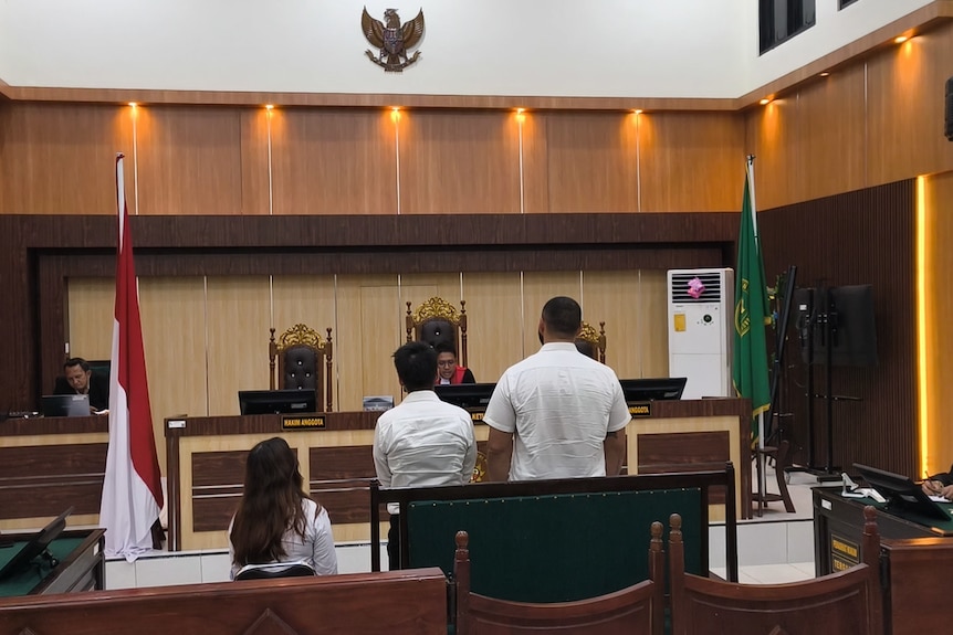 two men stand before a judge in court