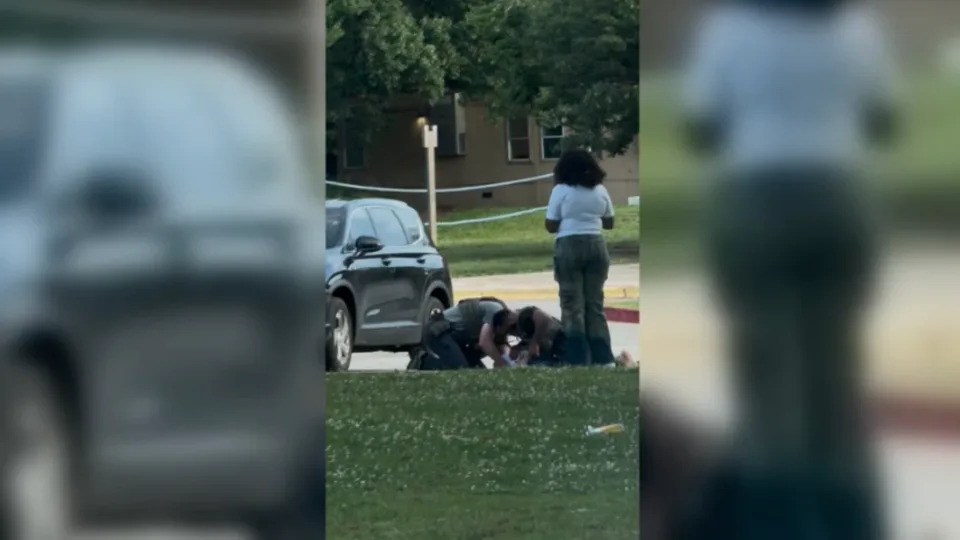 A man is seen being detained Thursday outside a Baltimore school. - Jude Castellanos