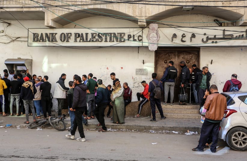 Employees of the Palestinian Authority line up at the ATM outside the Bank of Palestine in Rafah, in the southern Gaza Strip, on December 8, 2023