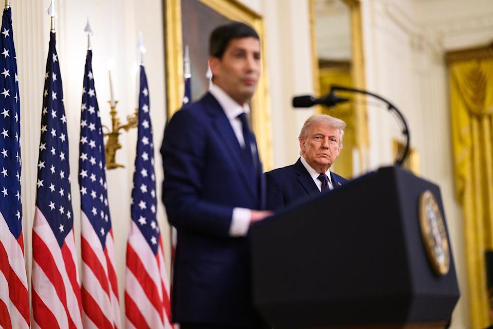Donald Trump eyeing Kevin Warsh as he delivers a speech in the East Room of the White House.