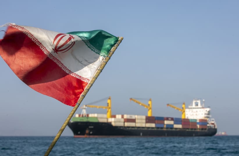An Iranian flag flutters in the wind as ships remain anchored in the Strait of Hormuz on May 16 2025. 