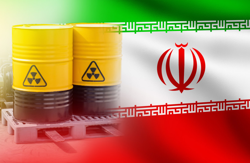 An illustrative image of uranium barrels over a backdrop of the Iranian flag.