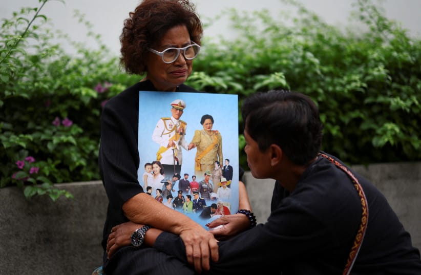 People react while holding a picture of Thai King Maha Vajiralongkorn and Thailand's Queen Mother Sirikit, 93, following the announcement of her death, outside King Chulalongkorn Memorial Hospital in Bangkok, Thailand, October 25, 2025.