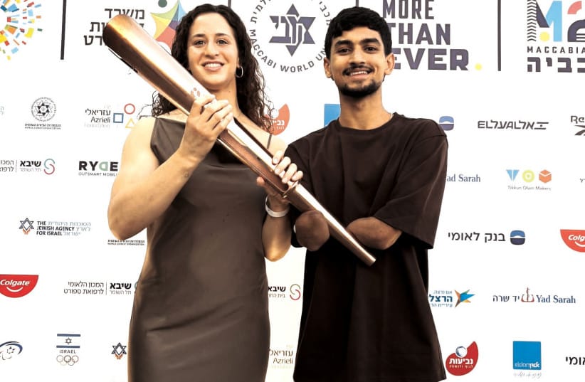 OLYMPIC JUDO silver medalist Inbar Lanir (left) and Paralympic taekwondo champion Asaf Yasur (right) pose with the Maccabiah torch after being selected to light the flame at the opening ceremony of Maccabiah 2026.