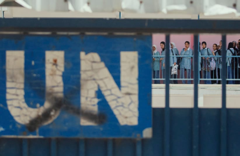 A ''UN'' sign is seen on a gate as students gather behind it in a UNRWA school during a military raid in Nablus, West Bank, on May 20, 2025.