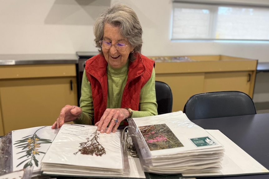 A medium shot of a woman looking at books