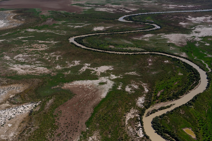 A channel of water weaves through greenery on either side