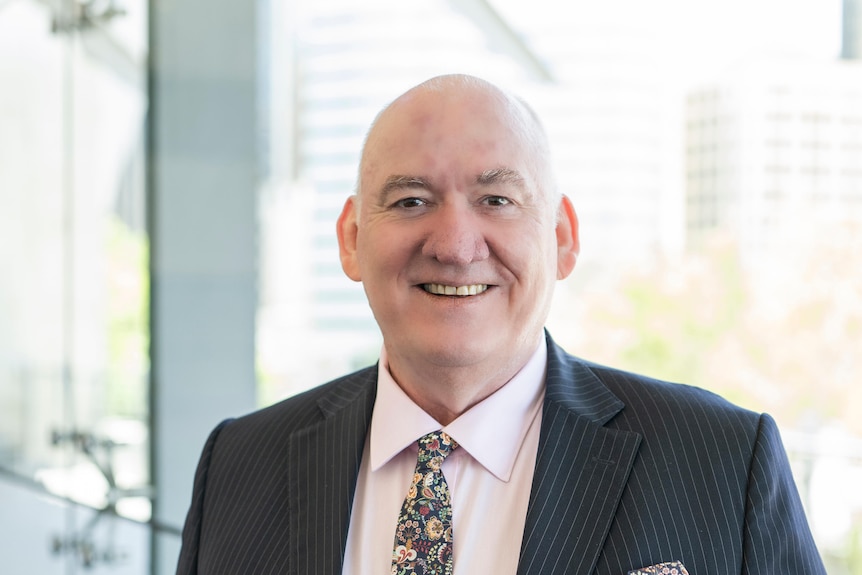 A headshot of a man with smart suit.