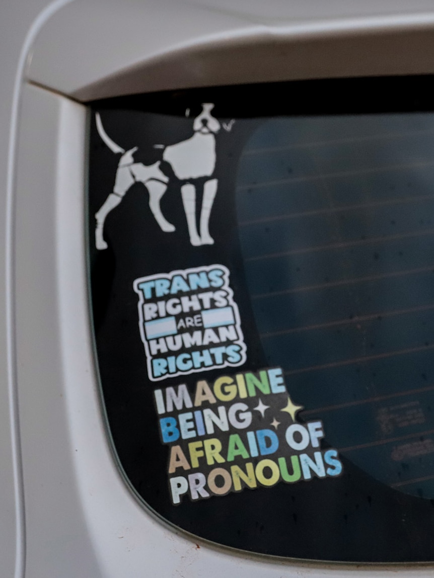 Stickers on the back windscreen of a white hatchback expressing support for LGBTIQ+ rights
