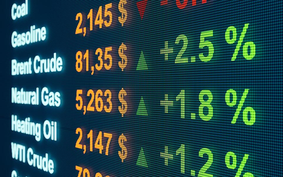 A screen displaying price movements of oil, natural gas, and related products with green up and red down arrows.
