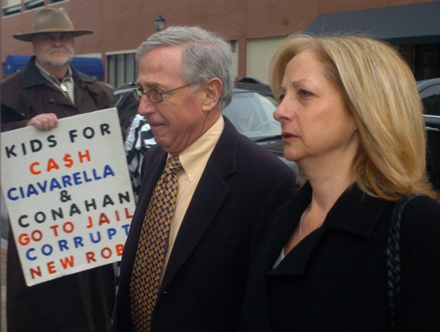 Mark A. Ciavarella Jr. and his then-wife Cindy pass a protestor while arriving for jury selection in the Kids-for Cash trial in February 2011. (CITIZENS' VOICE FILE).