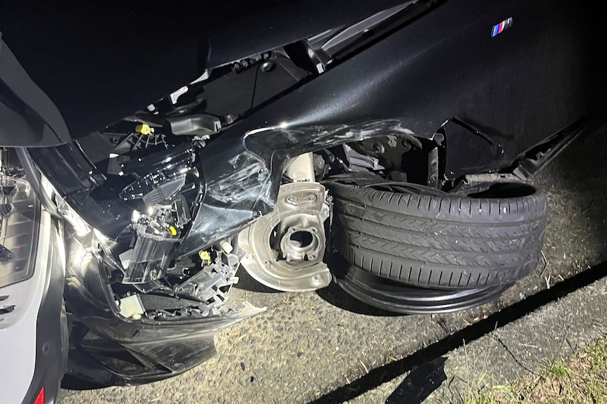Crumpled parts of a black BMW on the road where it crashed.