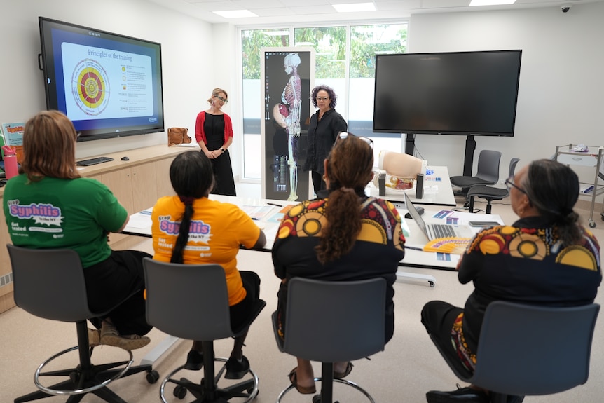 A small group of healthcare workers looking at a screen as part of a training session.