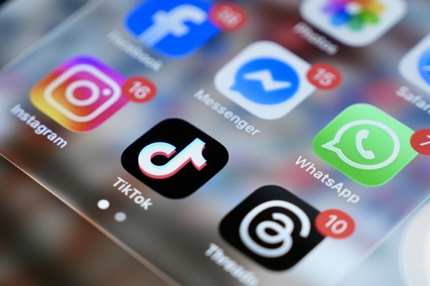 close up of social media apps on iphone screen including facebook, messenger, tiktok, instagram, threads and whatsapp