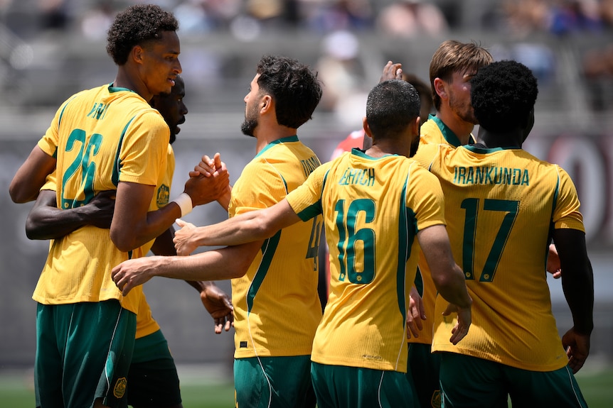 Tete Yengi of Australia celebrates with teammates after scoring a goal against Switzerland.