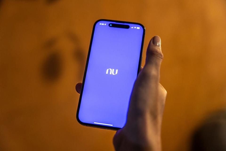 Person using Nu Holdings app on phone.