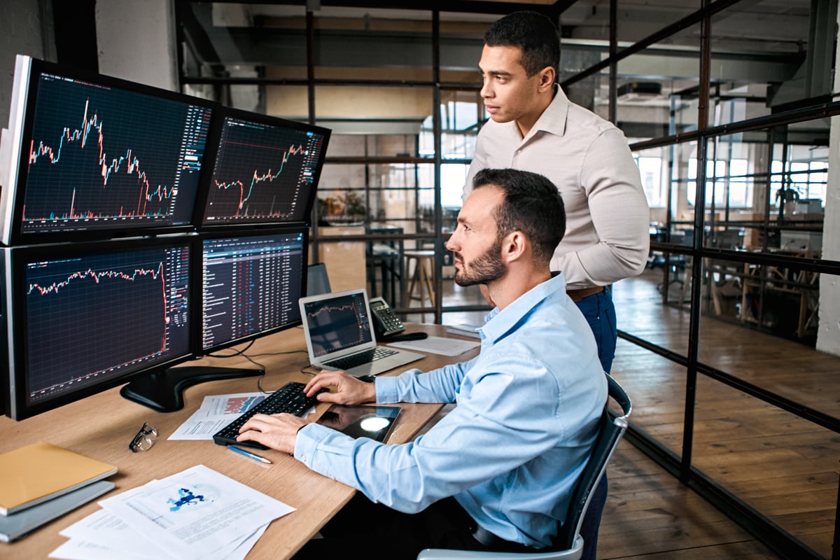 Two analysts looking at stock charts.