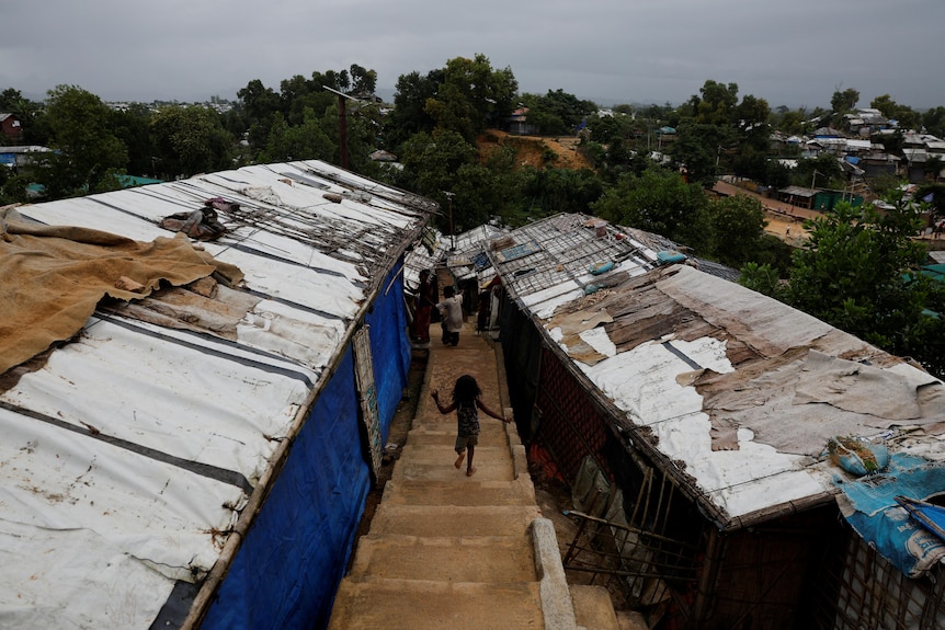 A child running down steps in a refugee camp.