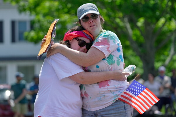 Biddeford City Councilor Abigail Woods hugs an unidentified constituent during an impromptu protest near the scene of a shooting involving U.S. Immigration and Customs Enforcement, Monday, July 13, 2026 in Biddeford, Maine. (AP Photo/Robert F. Bukaty)