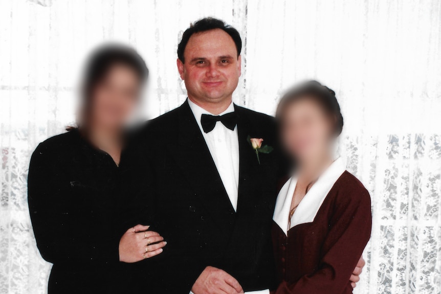 A man stands in a suit and bow tie