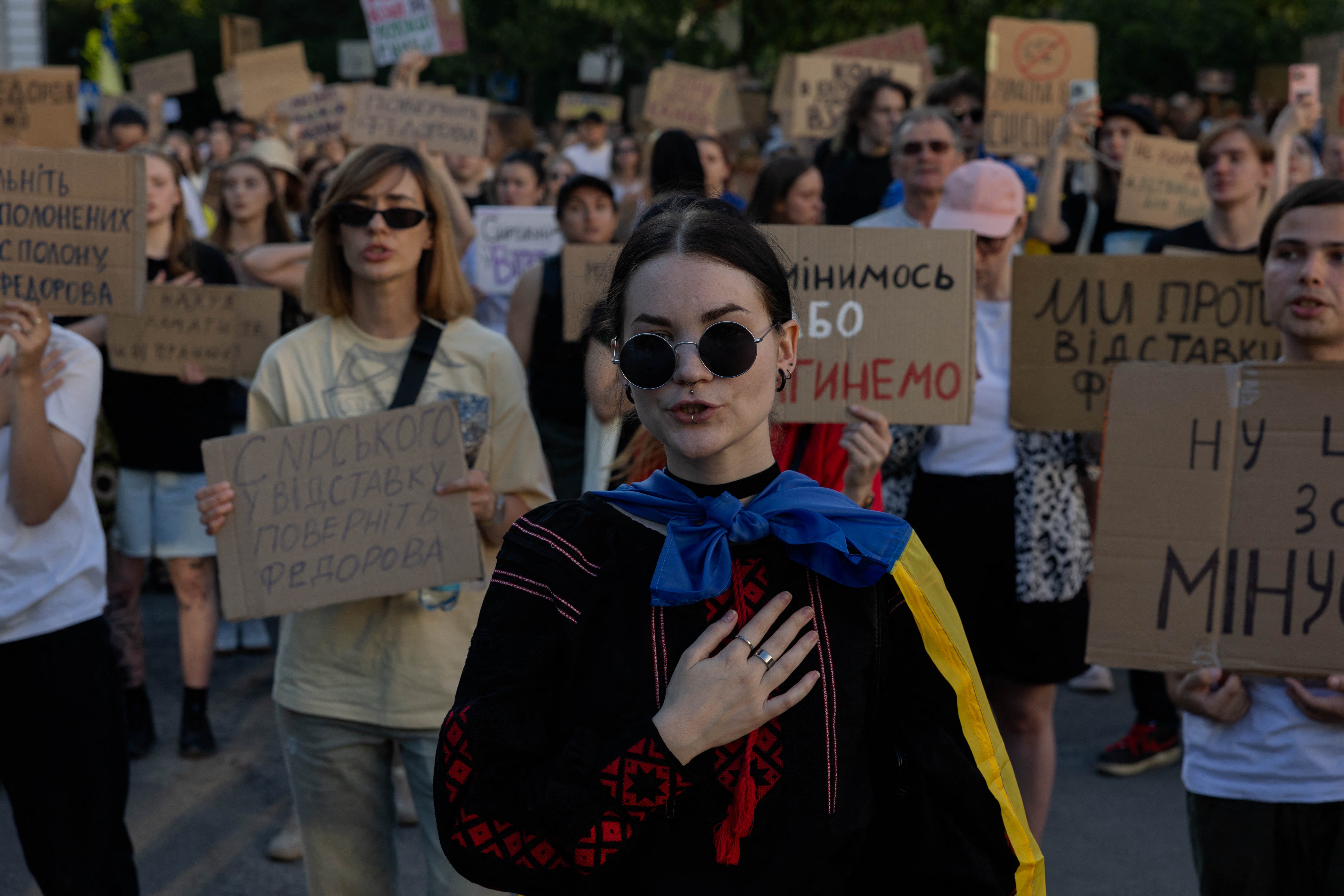 Protesters hold placards and chant slogans during a demonstration against Ukraine's president's decision to dismiss Ukraine's defence minister in Kyiv