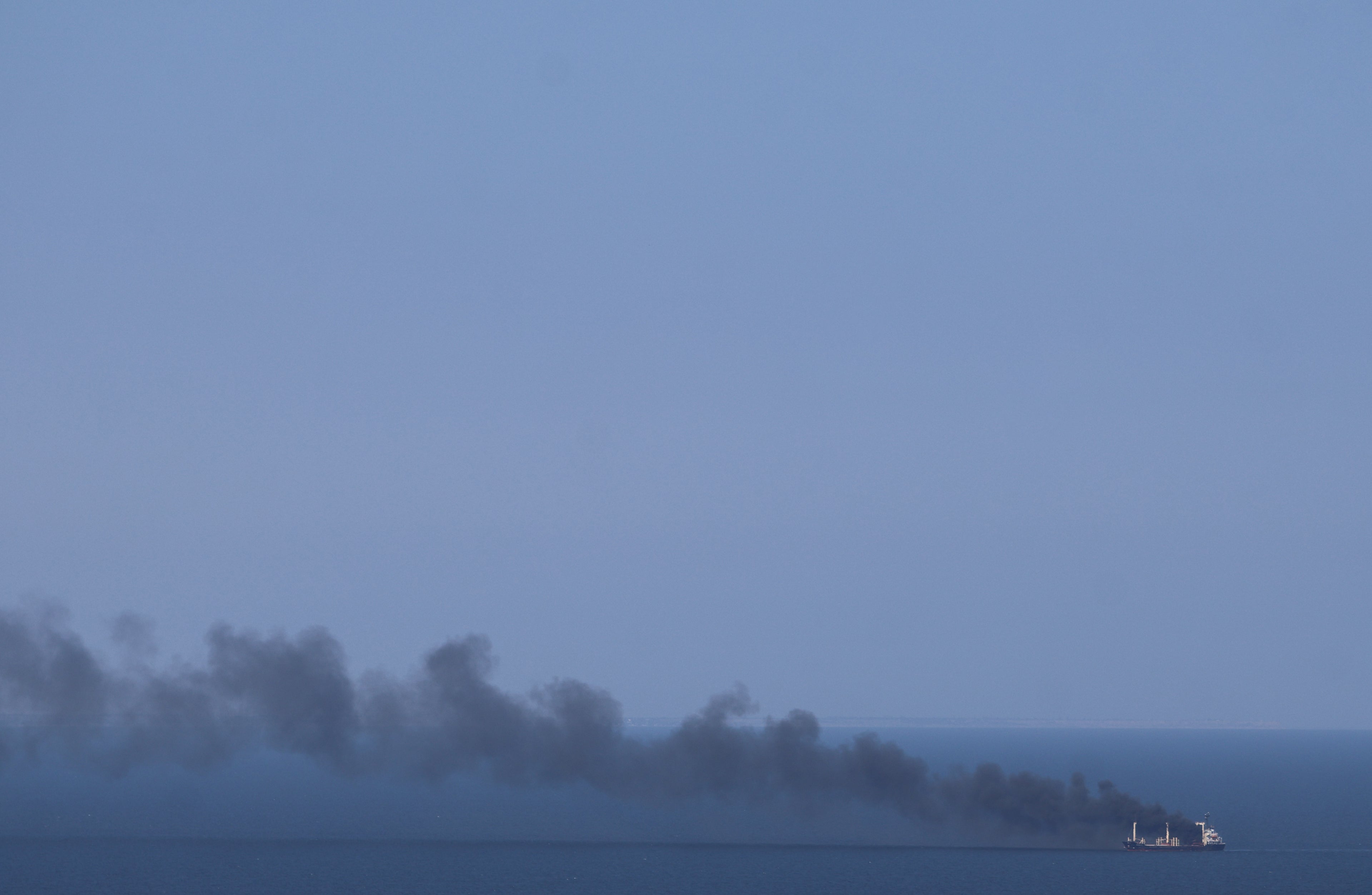 This photograph shows smoke rising from a civilian ship on the Black Sea off the coast of Odesa