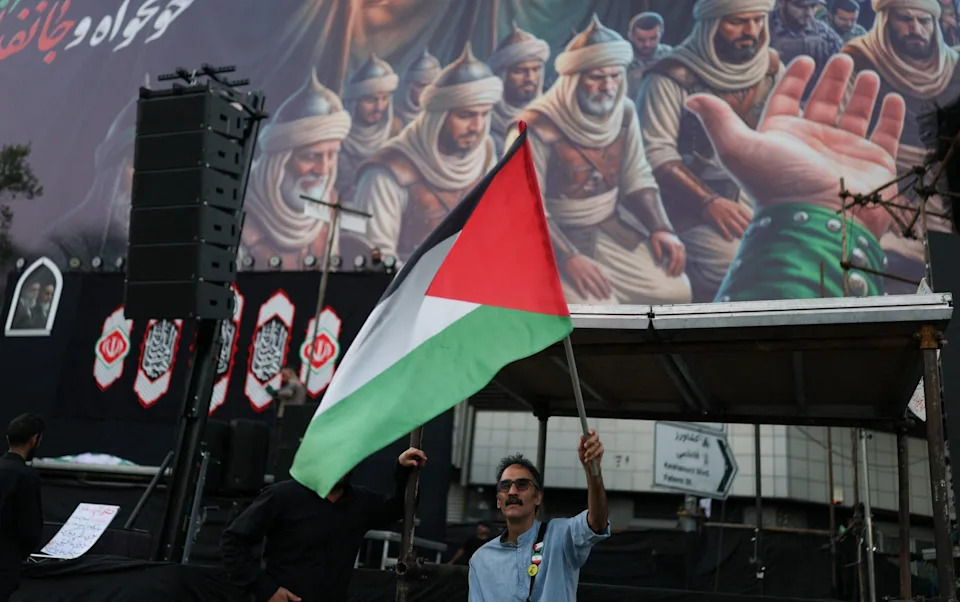 A man waves a Palestinian flag in Tehran during the preparations for the funeral of Ali Khamenei, which was delayed until a peace deal with the US was in place