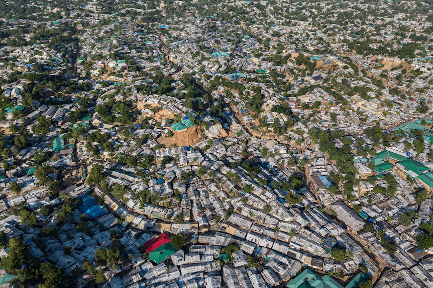 An aerial view of a refugee camp with thousands of makeshift shelters.