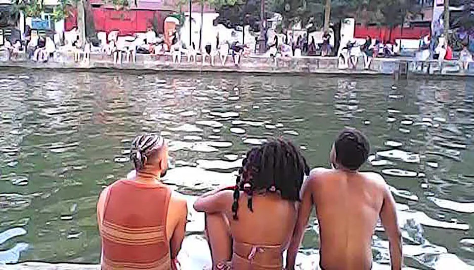 People sit along a canal