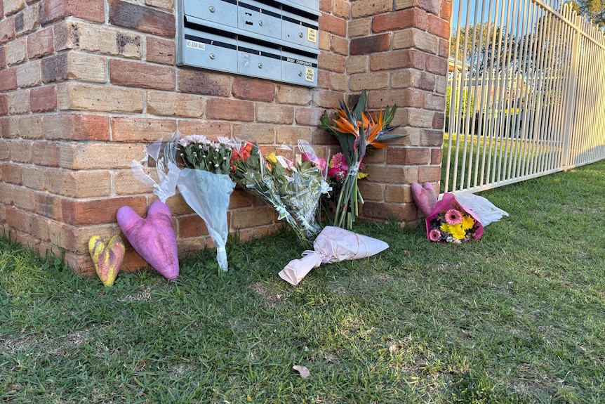 Floral tributes have been placed outside a red brick house.