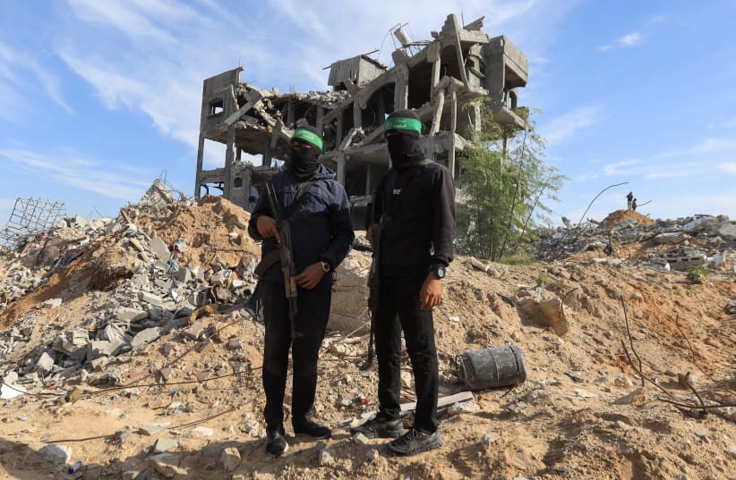 Palestinian Hamas terrorists stand guard at a site as Hamas says it continues to search for the bodies of deceased hostages, in Beit Lahiya in the northern Gaza Strip December 3, 2025.