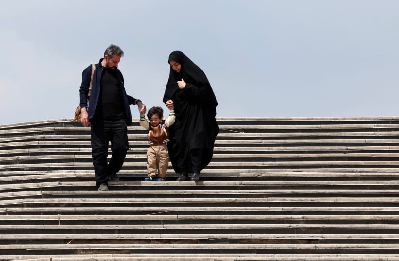 Iranians walk down stairs with a child at Tehran's Mellat park on April 2, 2026.