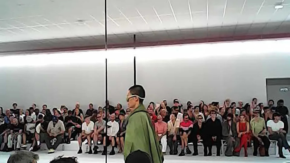 Seated attendees watch a model