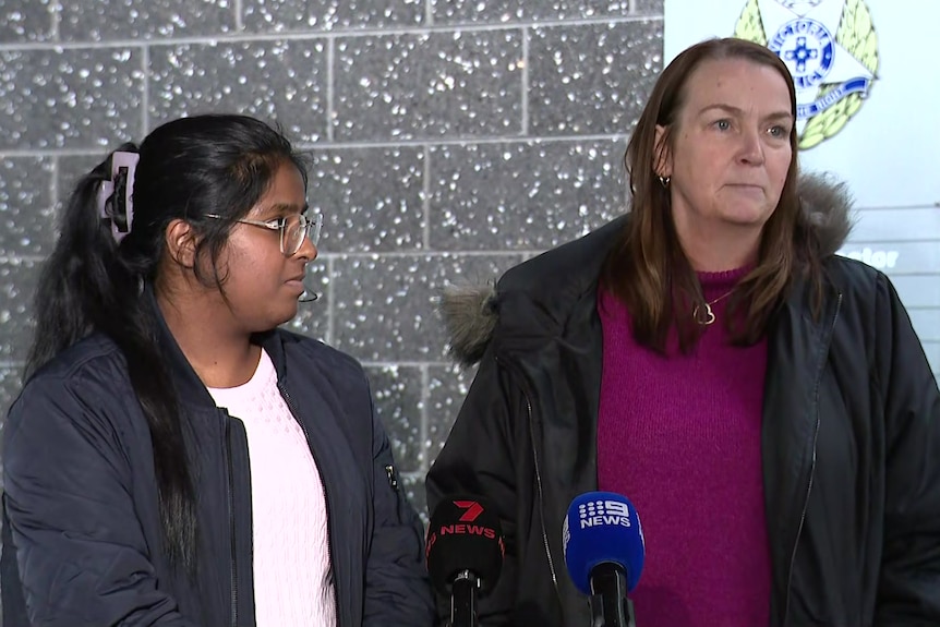 Two women talk to media reporters