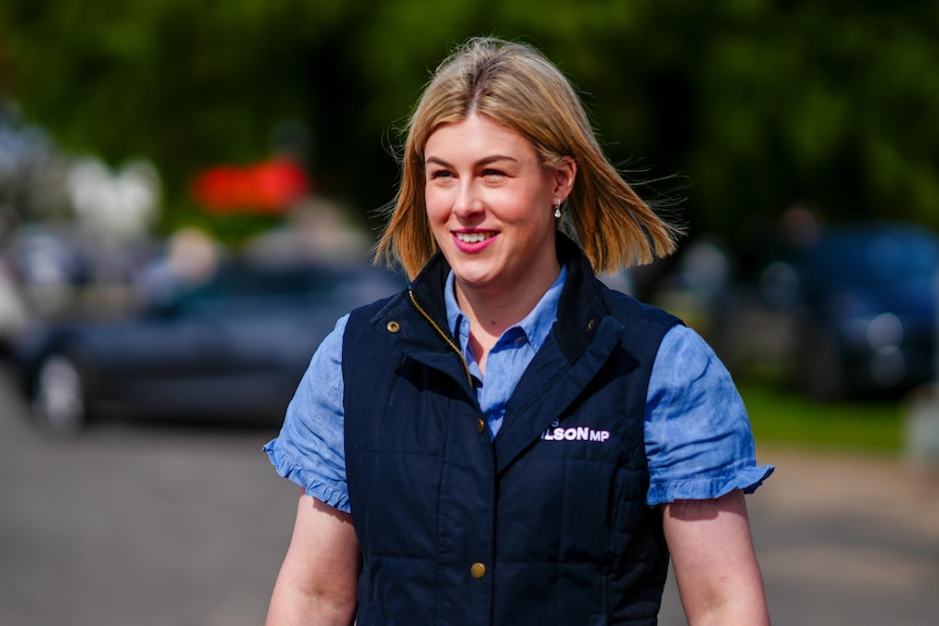 A woman smiles as she arrives to campaign on the hustings.