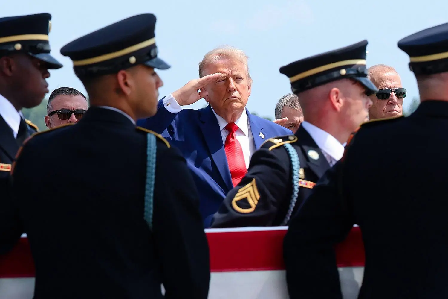 U.S. President Donald Trump is seen saluting as U.S. troops carry the casket containing the remains of a U.S. service member killed in the Iran war.