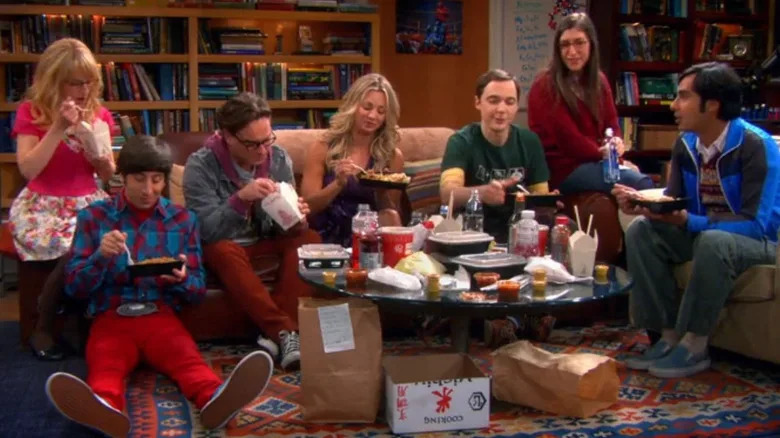 Sheldon sits in his spot while eating dinner with friends