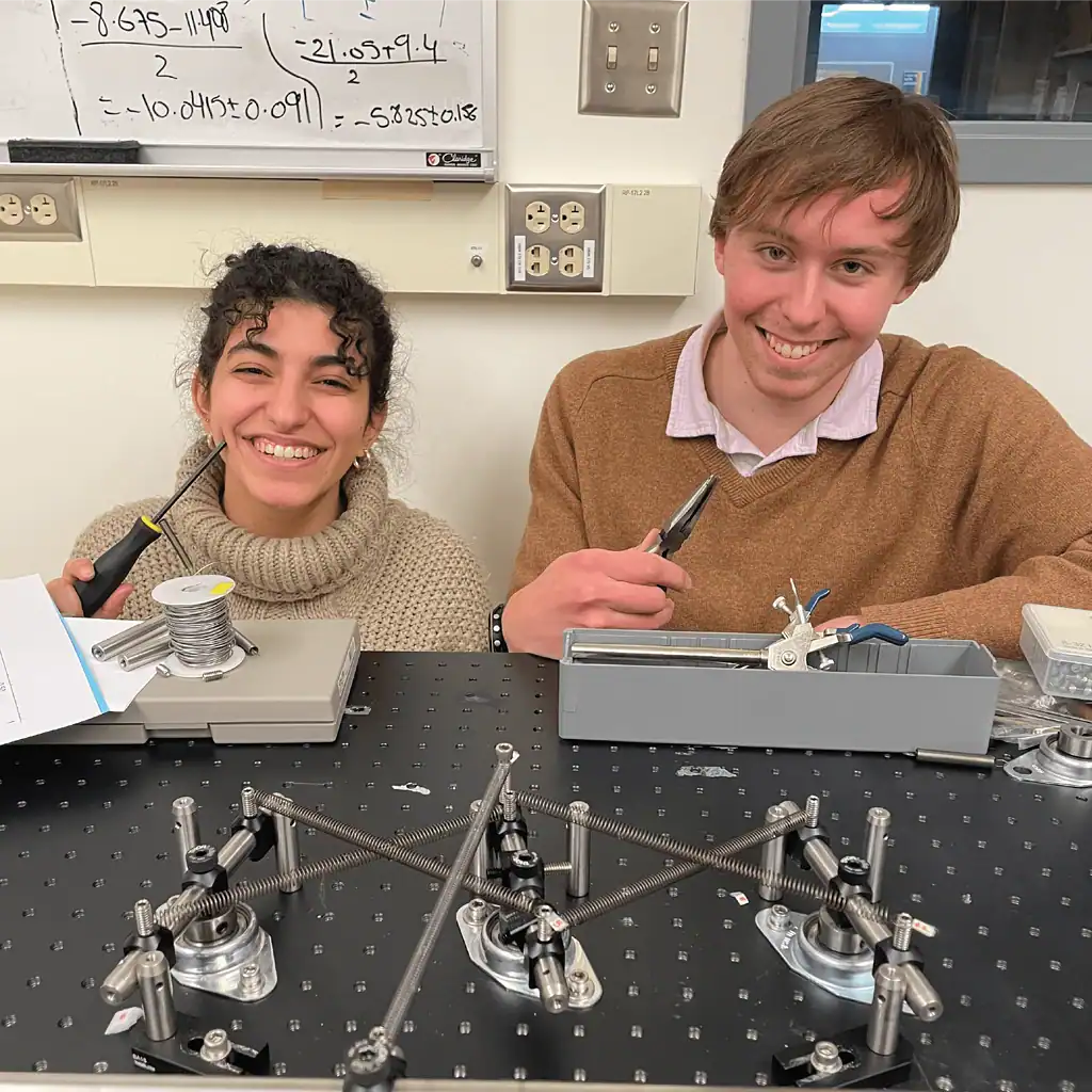 Smiling researchers with their mechanical computer in the foreground.