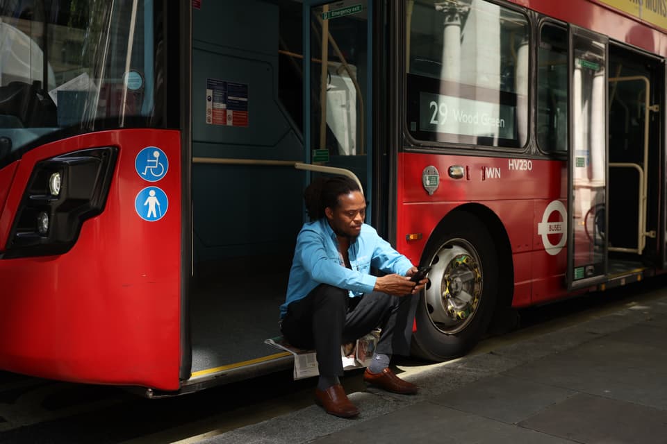 <p>London bus driver takes a break in the shade on June 26 during a heatwave</p>