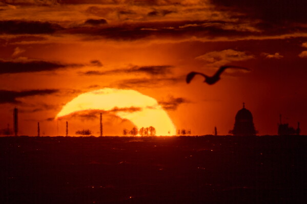 The moon and the sun set in the Gulf of Finland, during a solar eclipse in St. Petersburg, Russia, Wednesday, Aug. 12, 2026. (AP Photo/Dmitri Lovetsky)