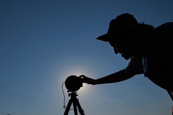 A member of the "Los Taraos" amateur astrophotography group, sets up his camera to shoot a total solar eclipse in Berlanga de Duero, central Spain, Wednesday, Aug. 12, 2026. (AP Photo/Bernat Armangue)