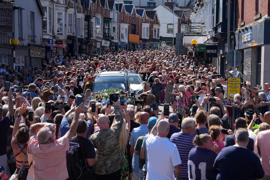 Fans crowd the hearse carrying pop legend Bonnie Tyler as it makes its way to her Welsh hometown. 