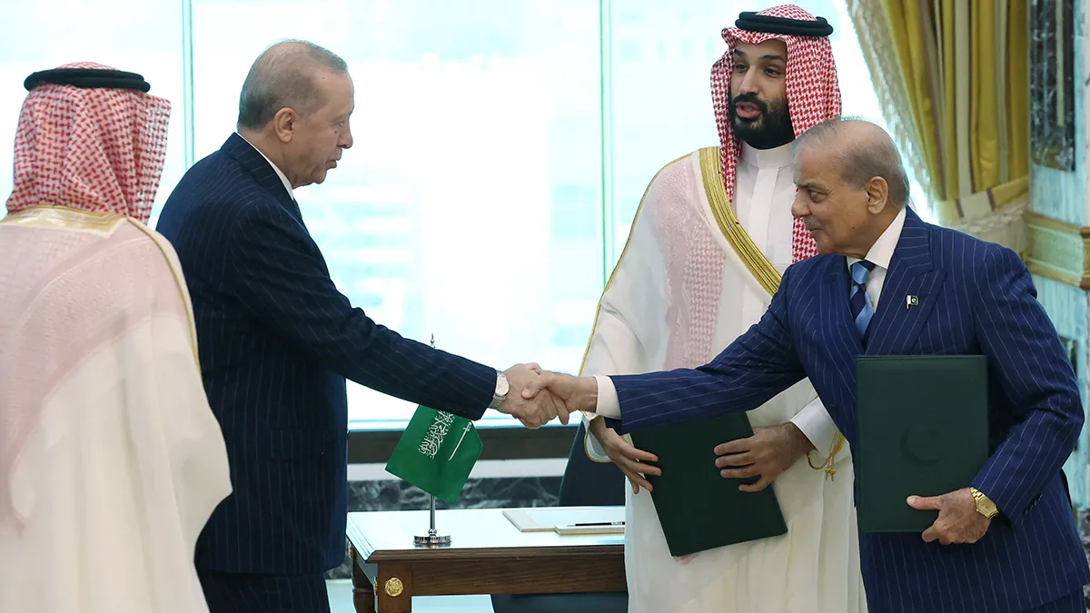 Turkish President Tayyip Erdogan shakes hands with Pakistani Prime Minister Shehbaz Sharif as Saudi Crown Prince Mohammed bin Salman looks on, following the signing of a joint defence agreement in Makkah, Saudi Arabia, on 7 August 2026 - Murat Cetinmuhurdar/Turkish Presidential Press Office/Handout via REUTERS