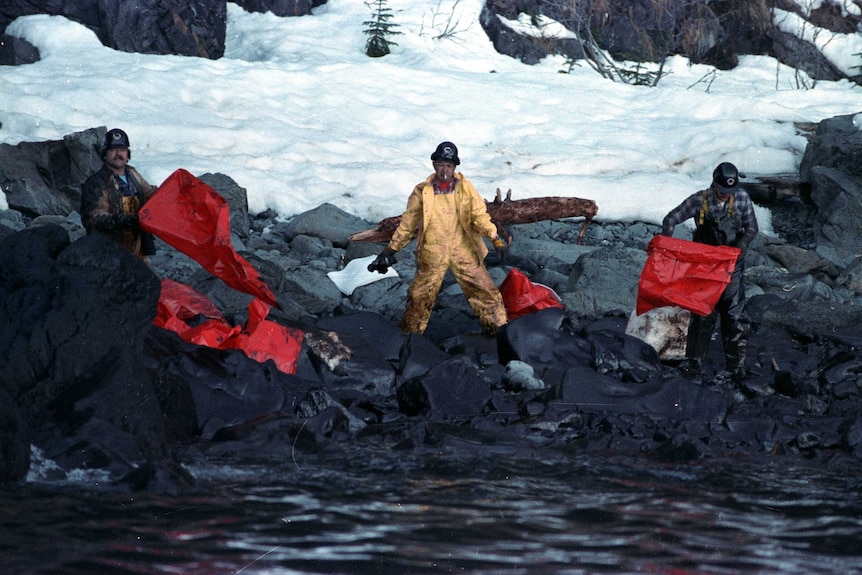 Workers covered in oil as they attempt to clean the Exxon Valdez oil spill