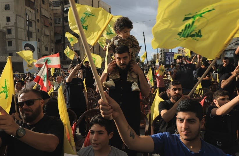 Supporters of Lebanon's Hezbollah wave flags while commemorating Israel’s withdrawal from southern Lebanon in 2000, in the southern suburbs of Beirut, Lebanon, May 25, 2026. 