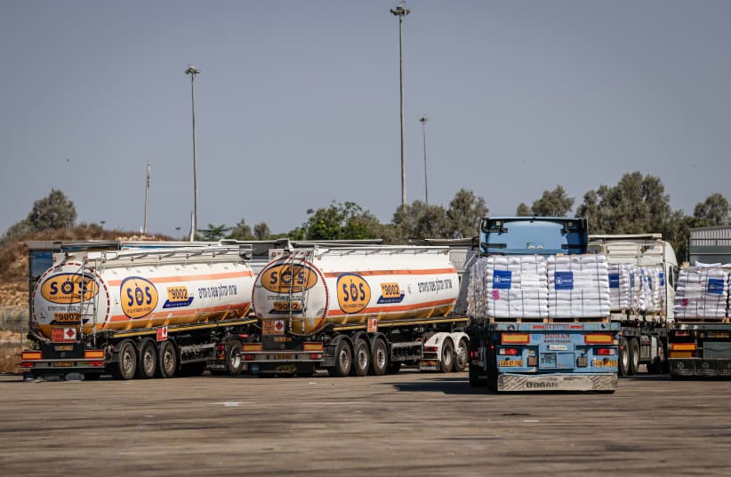 Trucks loaded with humanitarian aid wait at the Kerem Shalom crossing before entering the Gaza Strip from southern Israel, August 12, 2026. 